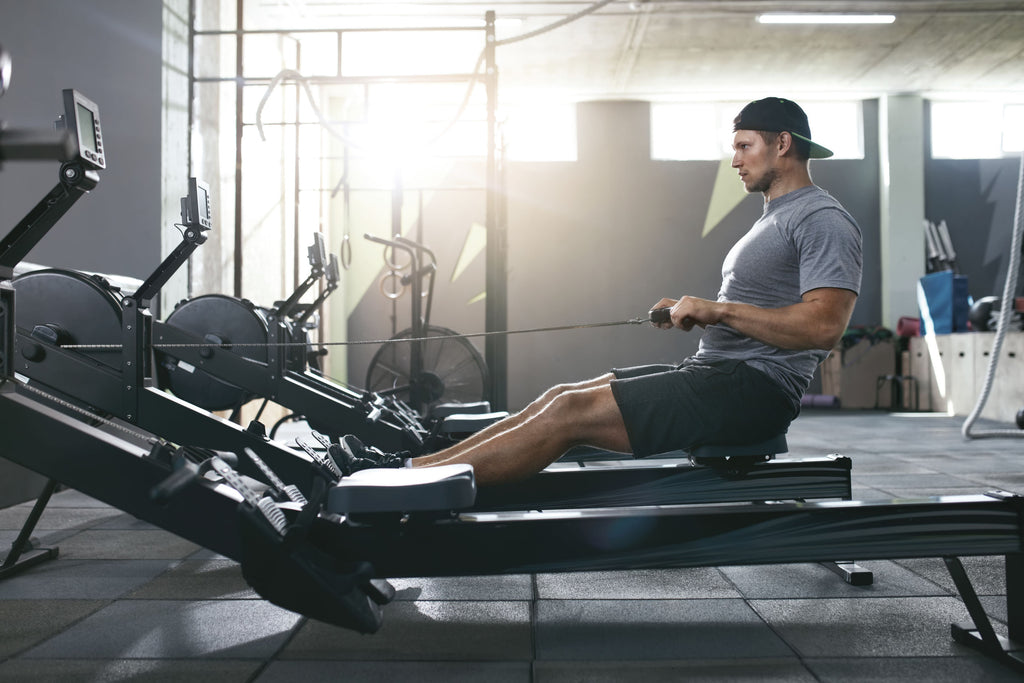 How much cardio should I do: A man uses a rowing machine at the gym