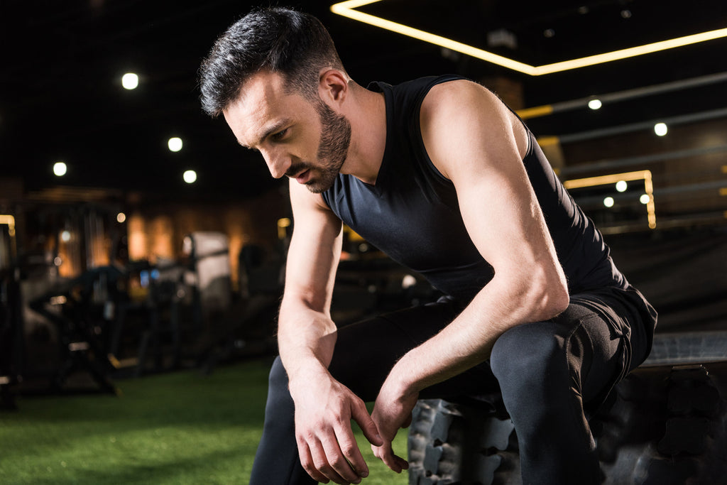 How much cardio should I do: A man sits, tired and discouraged after a workout