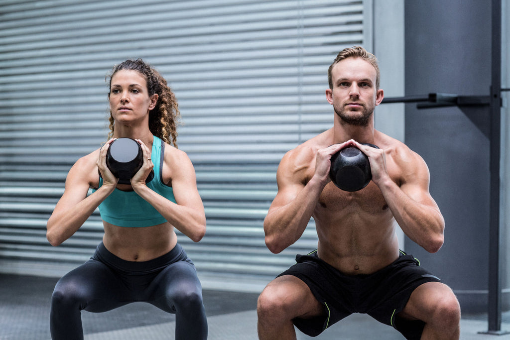 Do fat burners work: A man and woman do squats with kettle bells at the gym