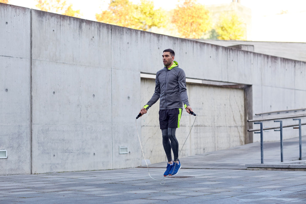 Fit man jumping rope on a rooftop