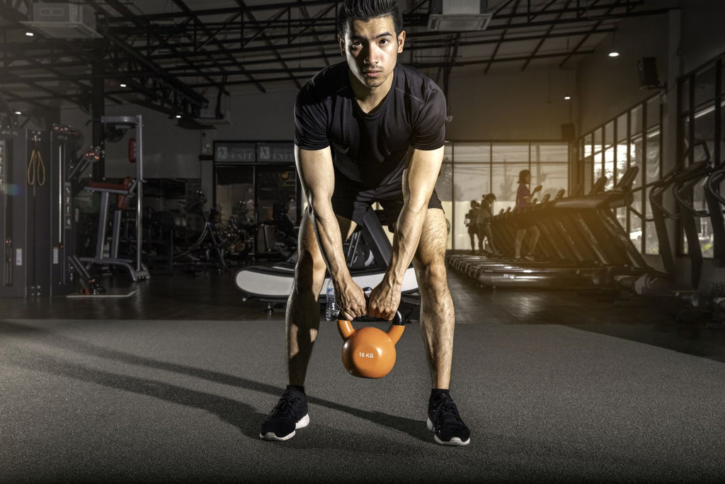 Man does kettleball swings as part of hamstring exercises