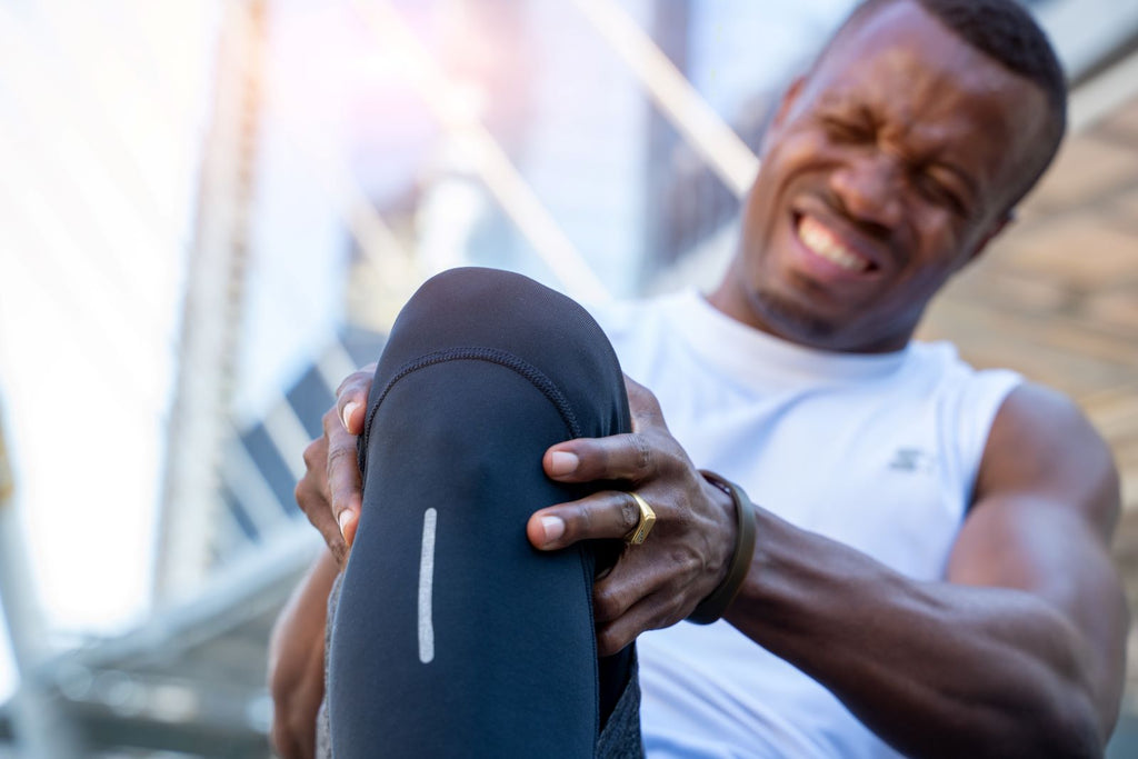 Joint supplements: Man holds knee in pain during workout