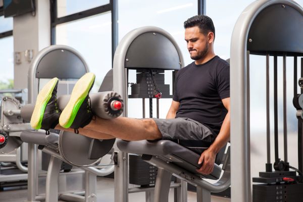 Man doing quad exercises with weights equipment